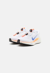 Białe buty sportowe z niebieskim logo Swoosh, pomarańczowymi akcentami, siateczkowym wierzchem i teksturowanymi podeszwami. Posiadają sznurowadła na zacisk oraz amortyzowaną podeszwę.