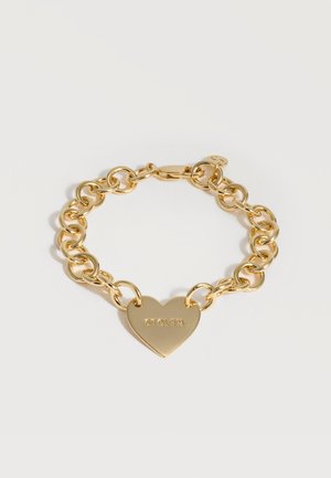 Βραχιόλι με χρυσή αλυσίδα και καρδιά-γούρι χαραγμένη με τη λέξη «STOLEN» σε λευκό φόντο.