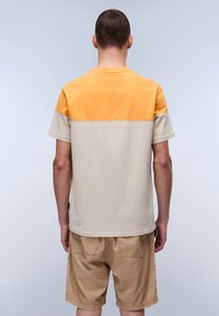 Kortærmet t-shirt med farveblokdesign, der har en gul topsektion og en beige bund. Lavet af blød bomuld, afslappet pasform.