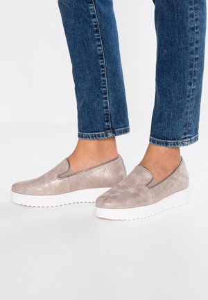 Beige slip-on sko med en glat metallisk finish og teksturerede detaljer, med en hvid platformssål.