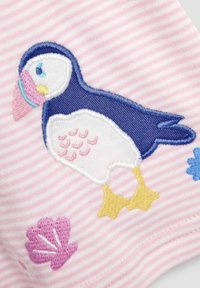 Vezen puffin v modri in beli barvi na roza črtastem materialu, dopolnjen s roza školjkami in modrimi cvetličnimi motivi. Mehka tekstura.