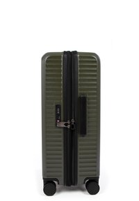 Valigia rigida di colore verde oliva, caratterizzata da scanalature orizzontali, doppia zip, lucchetto integrato e quattro ruote nere per la mobilità.