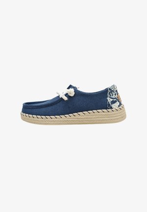 Zapato casual tipo slip-on azul marino con cordones de cuerda blanca, suela trenzada beige y detalle con estampado en el talón en azul y blanco.