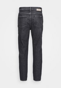 Jeans de mezclilla negros vistos desde atrás, con dos bolsillos parche y una pequeña etiqueta de marca blanca en la cinturilla.