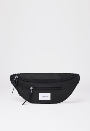 Czarna nerka z dwiema zapinanymi na suwak przegrodami i białą naszywką z logo Sandqvist na przodzie na jednolitym białym tle.