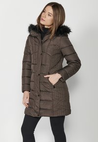 Padded brown parka-takki, jossa on irrotettava musta turkkihuppu, vinoneliökuviointi, etupainikkeet ja sivutaskut.