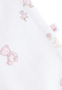 Tissu en coton blanc avec motifs de petits ours en dessin animé rose clair, fleurs et oiseaux. Comprend une petite étiquette avec un motif de lapin.