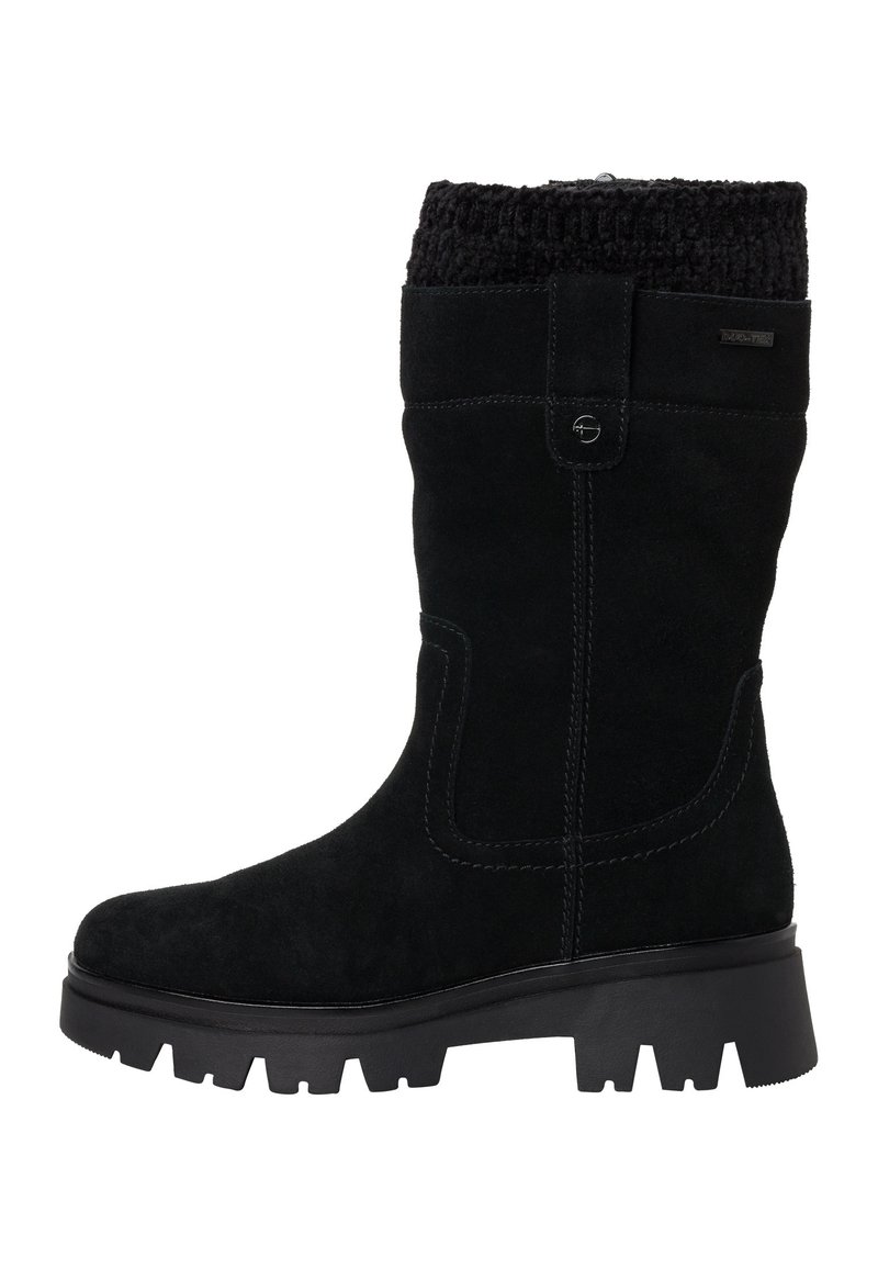 Musta mokkasukkinen polvipitkä saapas, jossa on teksturoidusta neuleesta valmistettu ääriviiva, kumipohja ja näkyvät ompeluyksityiskohdat. Varustettu sivupainikkeella kiinnitystä varten.
