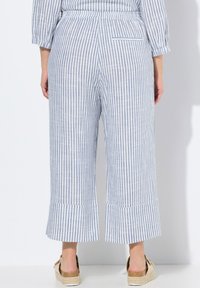 Blå och vit randiga culottes med vida ben, elastisk midja och en bakficka. Tillverkade av ett lätt material med en texturerad yta.