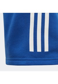 Blue cotton fabric with a smooth texture, featuring three vertical white stripes near the hem. Simple design and clean stitching.