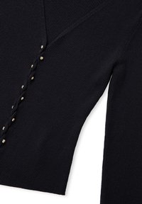 Rippensweater in Marineblau mit V-Ausschnitt, dekorativen goldenen Knöpfen an der Seite und einem geflochtenen Detail für zusätzliche Struktur.
