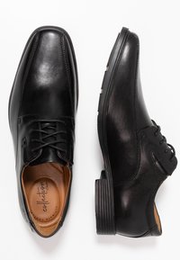 Zwarte leren schoenen met een gladde afwerking, ronde neus, vetersluiting en een getextureerde rubberen zool. Beschikt over een gevoerde binnenkant.