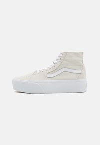 Witte hoge sneakers van suède materiaal, met een gestructureerd design, witte veters en een dikke witte zool. Minimale branding zichtbaar.