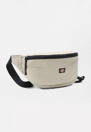 Beige heuptasje met zwarte rits en verstelbare riem, voorzien van een klein Dickies-logo op de voorkant.
