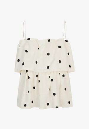 Vestido blanco sin mangas con tirantes finos, de corte suelto y con un patrón de lunares negros por todo el tejido.