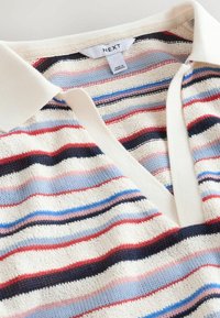 Strikket poloshirt med hvid krave og flerfarvede vandrette striber i rød, blå, sort og pink, mærket "NEXT" fremstillet i Cambodja.