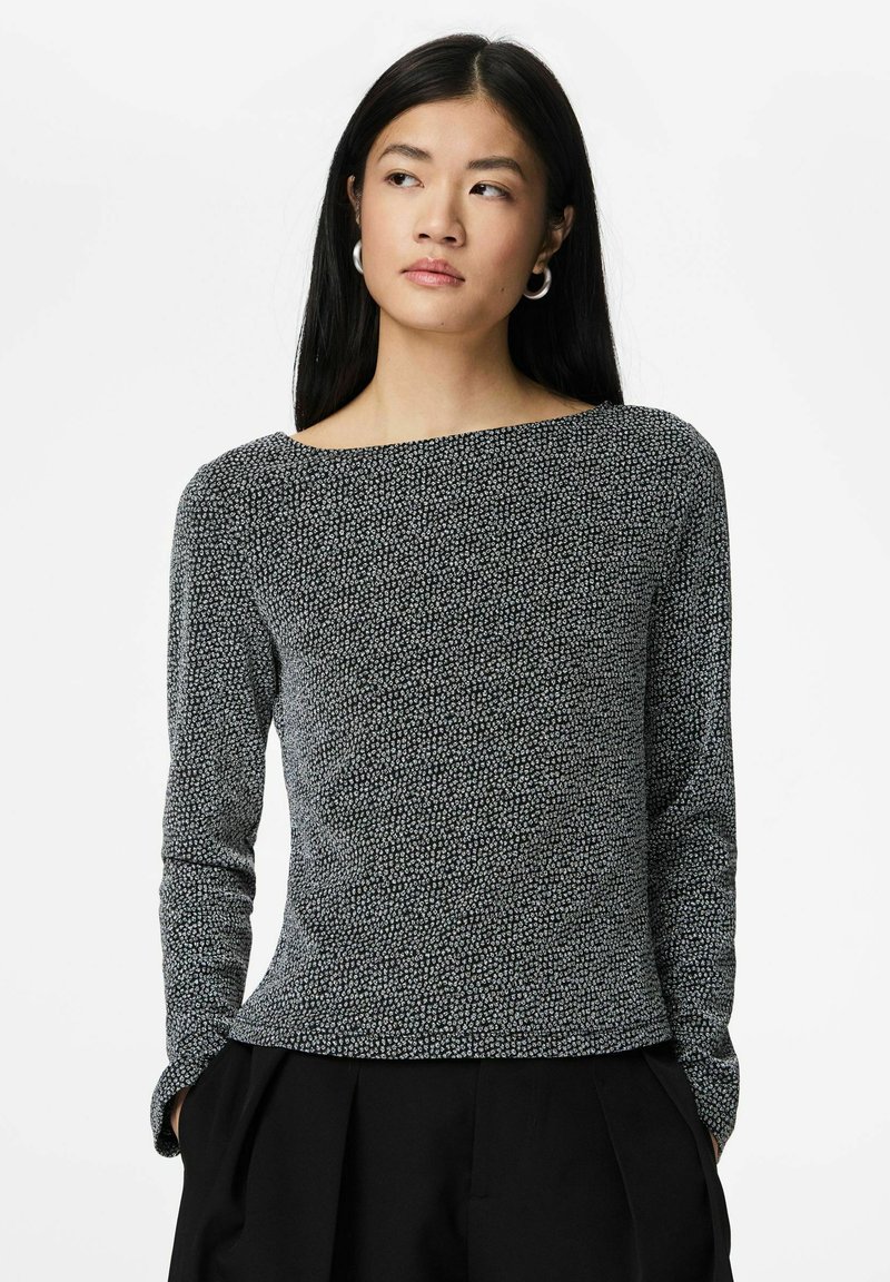 Juodas ilgarankovis viršus su tekstūruotu raštu, plačiu valtimi primenančiu iškirpimu ir prigludusia silueto linija. Derinamas su juodomis aukšto liemens kelnėmis.