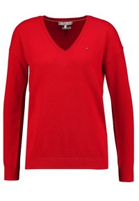 Pull rouge en V à manches longues, fabriqué en tissu doux. Présente un logo Tommy Hilfiger sur la poitrine, ainsi que des détails côtelés au niveau de l'ourlet et des poignets.