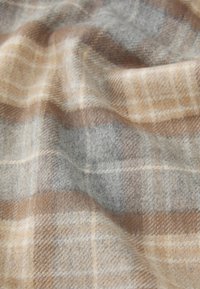 Plaid fabric in gray, brown, and beige tones. Soft wool texture features a classic grid pattern with light and dark squares.