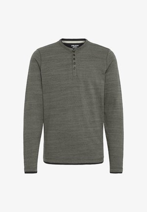 Tumši zaļš krekls ar garām piedurknēm un smalku svītrotu faktūru, ar pogājamu kaklu un kontrastējošām melnām maliņu apdare pie piedurknēm un apakšmalas.