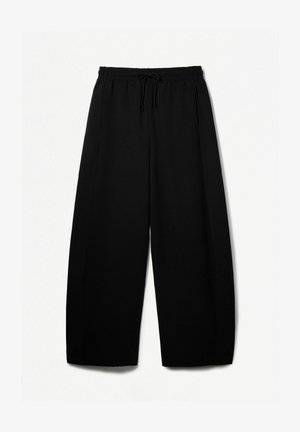 Pantaloni neri a gamba larga con vita elastica e cordoncino. Tessuto morbido con una superficie liscia. Taglio dritto con cuciture laterali.