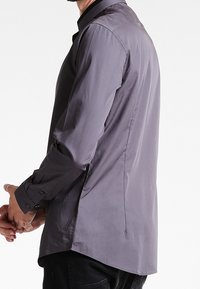 Grijze langemouwshirt met een knoopsluiting bij de kraag, rechte snit en een gladde textuur. Kenmerkt zich door knoopsluitingdetails bij de manchetten en een rugventilatieontwerp.