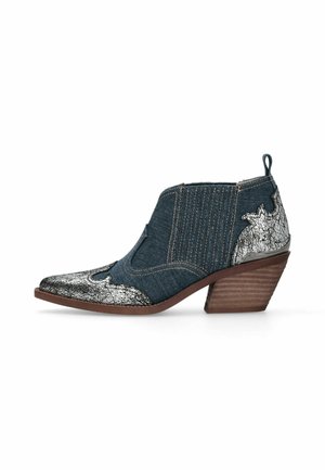 Botte en denim hauteur cheville avec des accents en cuir argenté craquelé, bout pointu, talon bois empilé et panneaux latéraux élastiques pour un enfilage facile.