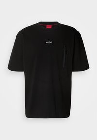 Černé tričko s krátkým rukávem vyrobené z bavlny, s minimalistickým designem, zipovou kapsou a logem na hrudi. Akcenty v červené barvě.