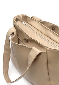 Bež torba od kože s glatkom teksturom, koja ima zatvoren džep s patentnim zatvaračem, kopču na dugme i dupla ručka za nošenje.