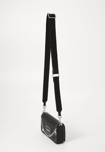 Μαύρη ορθογώνια τσάντα crossbody με λευκή ραφή, ασημί αξεσουά�ρ και ρυθμιζόμενο φαρδύ υφασμάτινο λουρί, πάνω σε απλό φόντο.