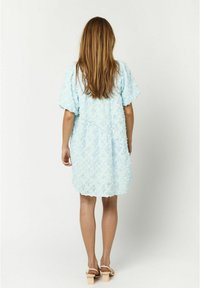 Helles blaues Spitzenkleid mit kurzen Puffärmeln, lockerer Passform und gewelltem Saum. Verfügt über ein florales Muster und eine leichte Textur.