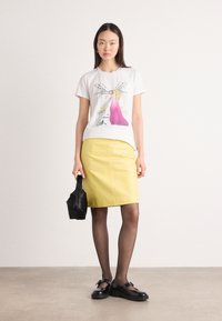 White t-shirt with a graphic print, yellow pencil skirt, black bag, black shoes, and sheer black tights. Smooth textures, fitted design.