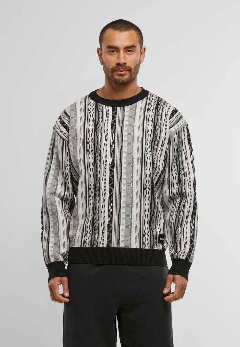 Schwarzer und grauer gemusterter Pullover mit vertikalen Streifen, gerippten Bündchen und Saum sowie einem runden Halsausschnitt. Hergestellt aus strukturiertem Strickmaterial.