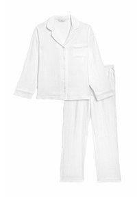 Ensemble de pyjama blanc en coton texturé. Comprend une chemise à manches longues avec un col et une poche, ainsi qu'un pantalon assorti à taille élastique.