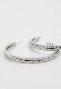 Sølv hoop øredobber med et dobbeltbånddesign, prydet med små klare rhinestones langs den ene kanten og intrikate mønstre.