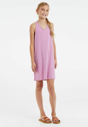 Lila ärmelloses Kleid aus weichem Stoff mit einem V-Ausschnitt. Das Model trägt braune Sandalen mit Riemen und hat die Haare zu einem Zopf geflochten.