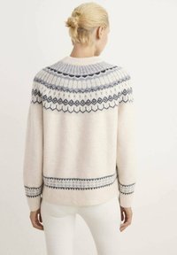 Maglione chiaro con dettagli intricati in grigio e blu navy, collo rotondo e polsini a coste. Tessuto morbido con una vestibilità rilassata.