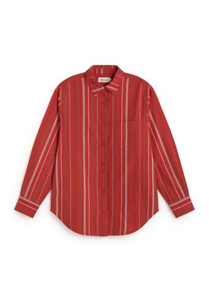 Chemise rouge à manches longues boutonnée avec des rayures verticales de différentes largeurs en blanc, beige et marron, avec un col et une poche poitrine.