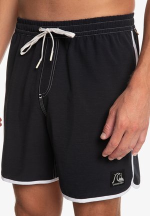 Czarne kąpielówki z białym sznurkiem, kontrastowymi akcentami po bokach, elastycznym paskiem w talii oraz małą naszywką z logo w dolnej lewej części.