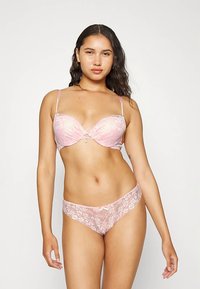 Rožinė nėriniuota liemenėlė su lankeliais ir plonais reguliuojamais petnešėlėmis, derinama su nėriniuotomis kelnaitėmis, puoštomis gėlių raštu ir kaspino akcentu.