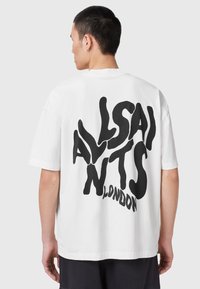 Camiseta blanca de algodón con un atrevido texto negro en la parte posterior que dice "ALLSAINTS LONDRES", de corte relajado y mangas cortas.