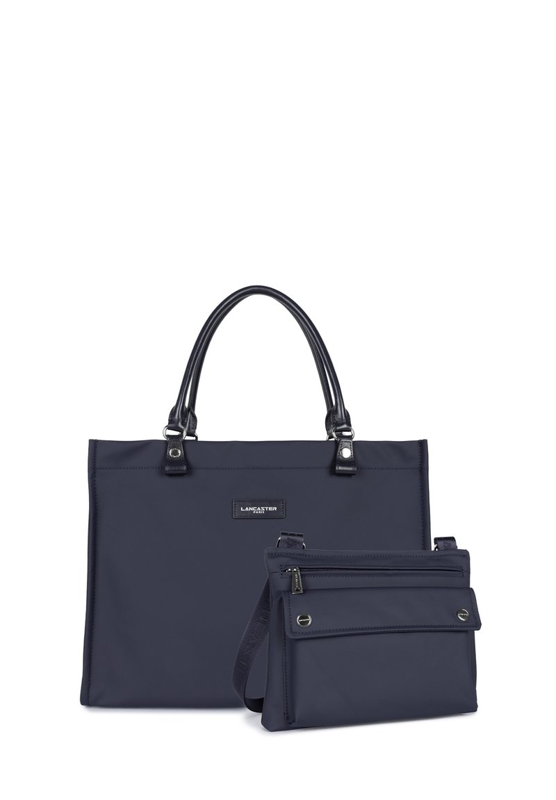 Borsa tote in nylon blu con manici in pelle nera e accessori metallici; include una piccola pochette coordinata con chiusura a zip e tracolla regolabile.