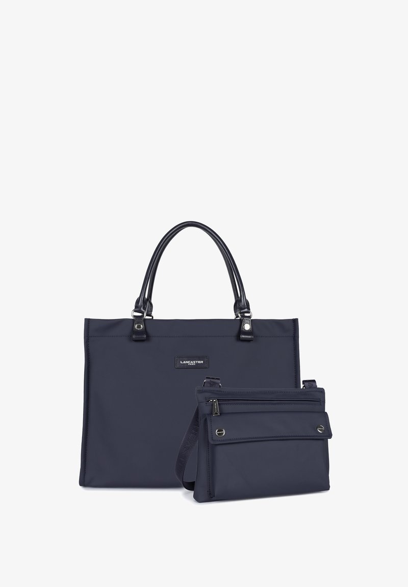 Borsa tote in nylon blu con manici in pelle nera e accessori metallici; include una piccola pochette coordinata con chiusura a zip e tracolla regolabile.