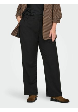 Osoba ubrana w czarne spodnie o szerokich nogawkach, brązowe zamszowe botki za kostkę, czarną bluzkę oraz brązową kratkowaną marynarkę z podwiniętymi rękawami.