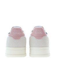Vita sneakers med en rosa mockapatch på hälen, präglat med "SINCE 1890". Slät läderöverdel, snörningsdesign och gummisula. Texturerade tygtillbehör.