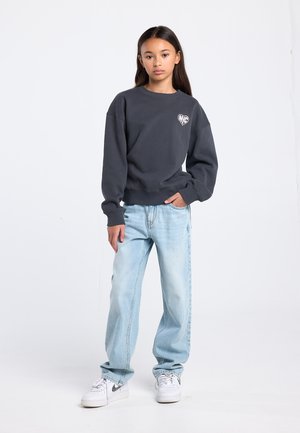 Gray sweatshirt with a heart logo, paired with light blue, loose-fitting jeans and white sneakers. Simple design, casual fit.