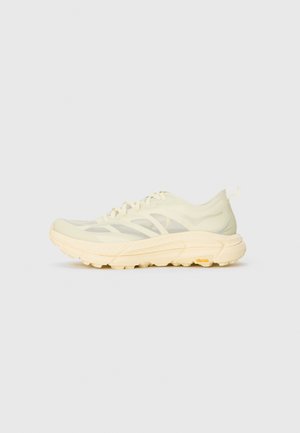 Light beige athletic sneaker with translucent upper, thick cushioned sole, side laces, and Vibram logo on the outer sole.