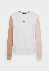 Nike sweatshirt in white with beige sleeves. Features a crew neckline and logo on the chest. Soft fabric with ribbed cuffs and hem.