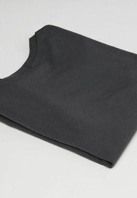 Schwarzes Crew-Neck-T-Shirt, ordentlich gefaltet, aus glattem Stoff mit leichtem Glanz, das ein sauberes, minimalistisches Design zeigt.