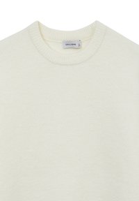 Pull crème avec un col rond, un ourlet côtelé et une texture douce. L'étiquette indique la taille L de la marque Calliope.